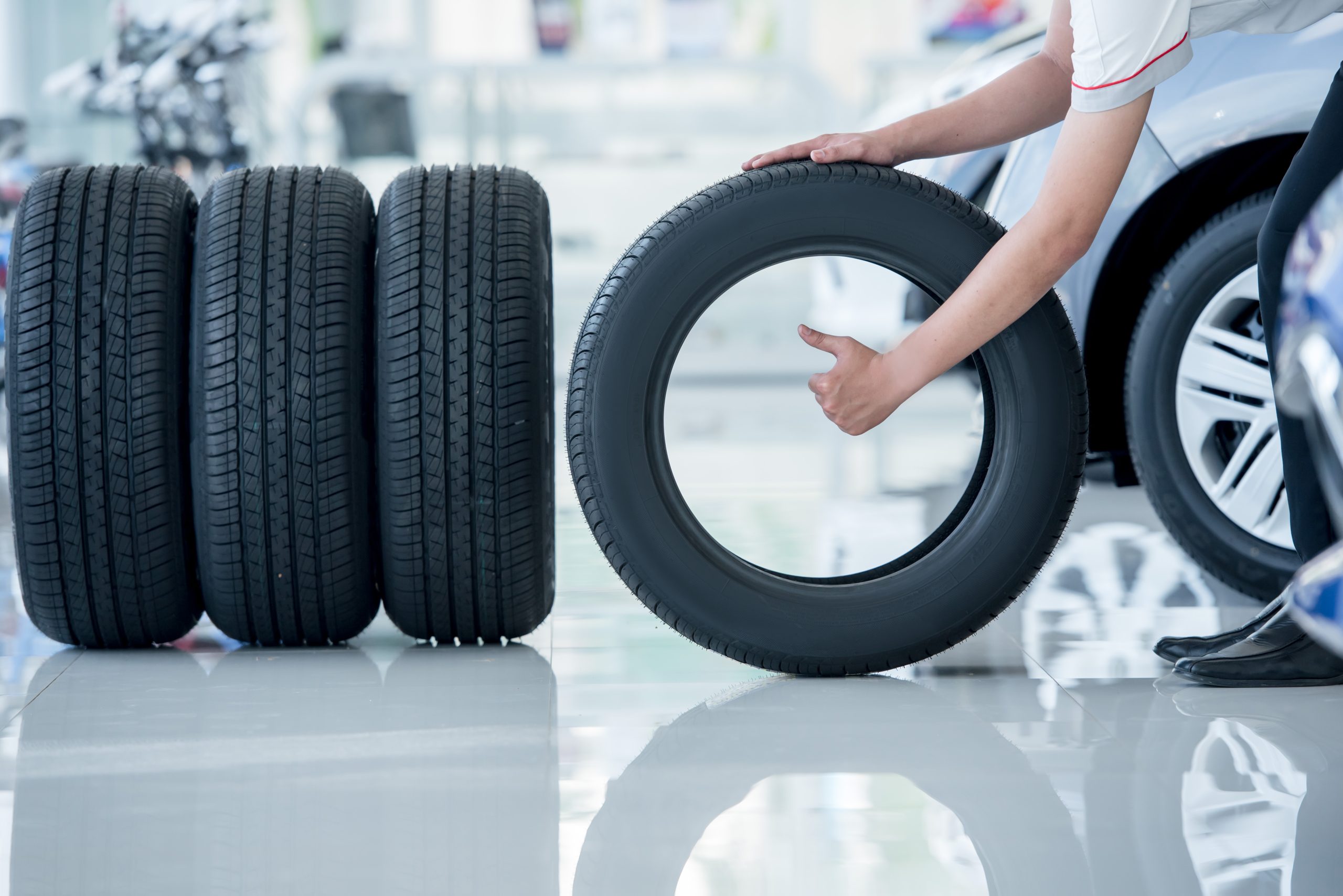 Person holding car tire indoors