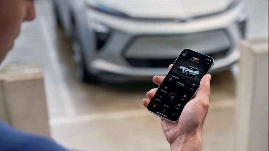 Person using myChevrolet app near vehicle