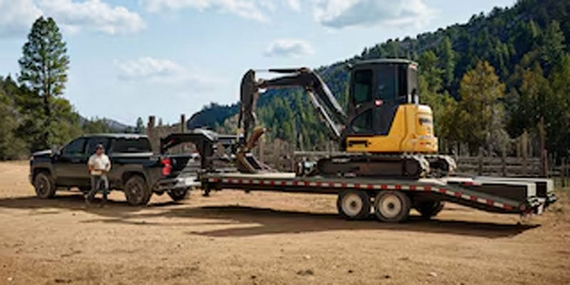 A 2026 Chevrolet Silverado 2500 HD towing a tractor in Benton, AR