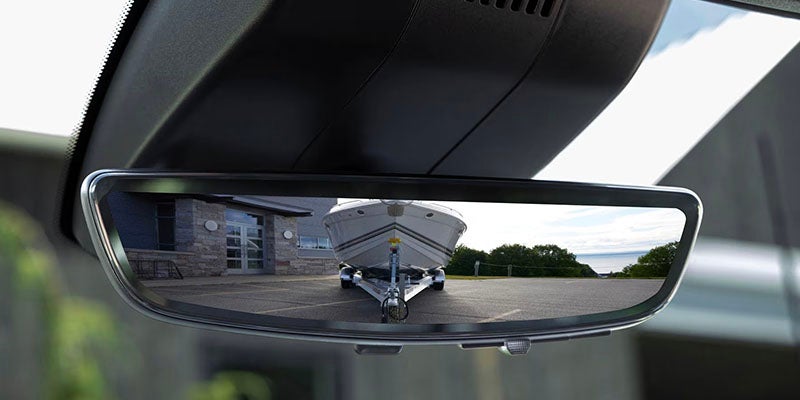 The rear view mirror showing your 2026 Chevrolet Silveardo 2500 HD towing a boat in Benton, AR